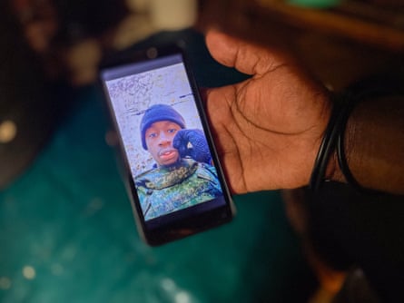 A selfie of David in military gear that Susan is showing on her phone