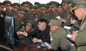 The North Korean leader, Kim Jong-un, looks at a computer along with military personnel