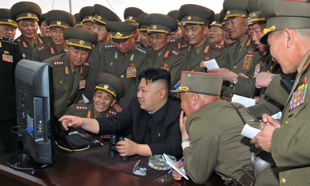 The North Korean leader, Kim Jong-un, looks at a computer along with military personnel