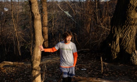 Lawrence Warriner leans against a tree in the forest