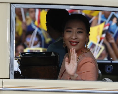 Thai Princess Bajrakitiyabha waves from inside a car, wearing a peach outfit and gold jewellery