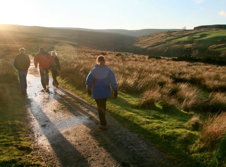 Walkers on the moors in low light above Haworth, a picturesque, historic village in West Yorkshire.