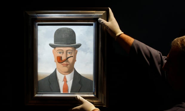 A worker adjusts a painting by Belgian artist Magritte in Brussels