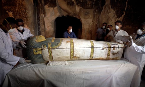 Archaeologists remove the cover of a ancient Egyptian sarcophagus in Luxor.