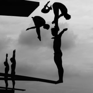 Silhouettes of divers on diving boards