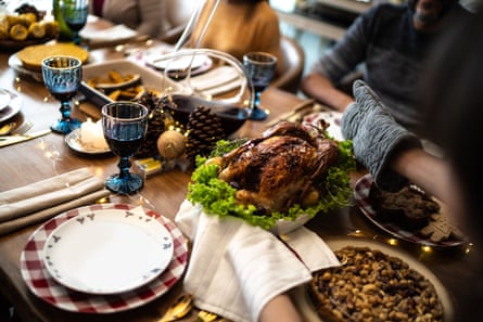 A roast turkey on a bed of lettuce at a festive dinner table