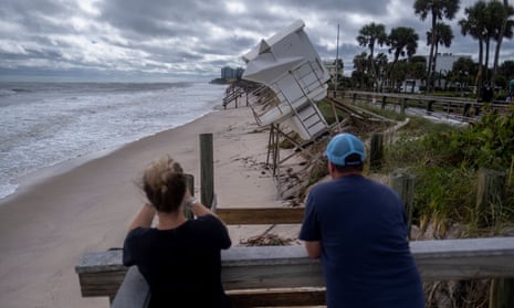 A couple looks at a damaged lifeguard tower following the passage of Hurricane Nicole in Vero Beach, Florida, on Thursday.