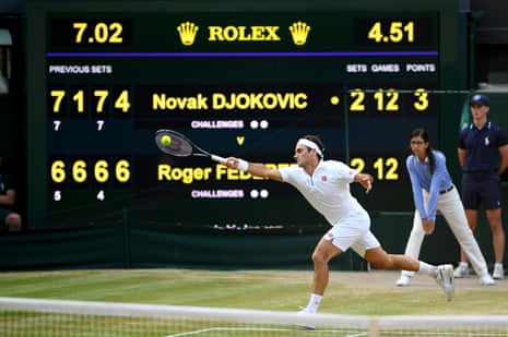 The scoreboard is seen as Roger Federer of Switzerland plays a forehand in the final set in the Men's Singles final between Novak Djokovic of Serbia and Roger Federer of Switzerland during Day thirteen of The Championships - Wimbledon 2019