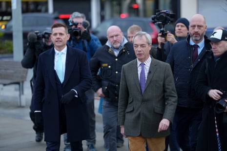 Reform leader Nigel Farage walking with Matt Goodwin and followed by a group of photographers