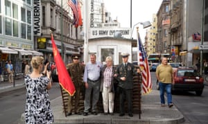 Tourists pose at the replica hut on the site of Checkpoint Charlie, Berlin