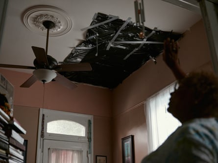 Darlene Jones covers a hole in her ceiling with trash bags to help contain air from leaking in and out of her house in New Orleans, Louisiana, on 12 November 2023.