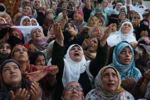 A dramatic image of a crowd of women looking to the sky, seeming to pray