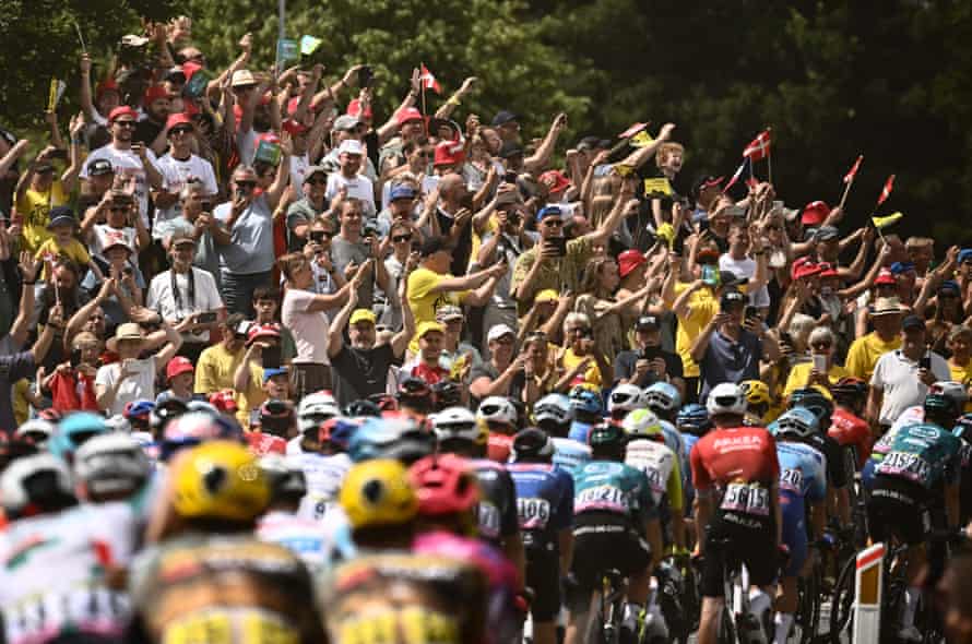Spectators cheer as the peloton goes past.