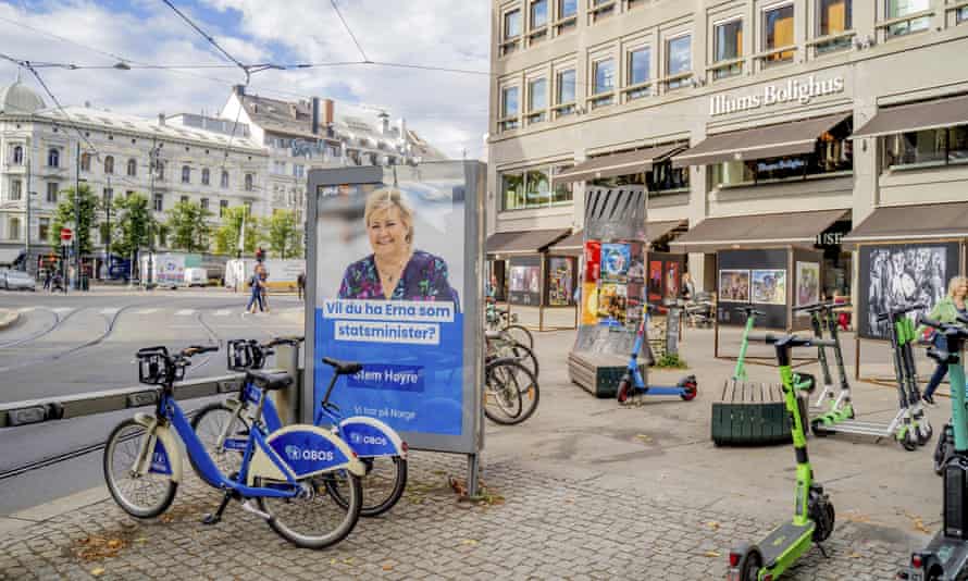 An election poster on an Oslo street is surrounded by bicycles and shows Norway’s prime minister, Erna Solberg.