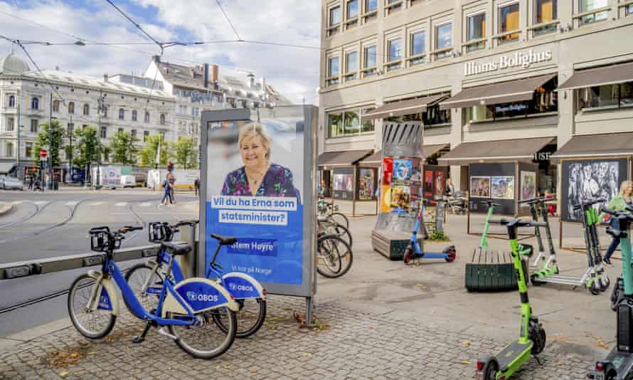 Oslo caddesindeki bir seçim afişi bisikletlerle çevrili ve Norveç başbakanı Erna Solberg'i gösteriyor.