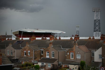 Blundell Park stadium seen from a distance behind streets of brick houses; it has a small stand with white roof that overlooks the pitch.