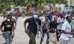 Los pasajeros del ferry huyen de la policía que dispara gases lacrimógenos después de que nuevas medidas para detener la propagación del nuevo coronavirus han provocado que se formen multitudes fuera del ferry en Mombasa, Kenia, el viernes 27 de marzo de 2020. Las nuevas medidas han solicitado el abandono de vehículos de transporte público de pasajeros a 1 km de distancia, a pie hasta la terminal del ferry y luego en una cola, pero los pasajeros temen quedarse atascados antes de que el toque de queda a las 19:00 comenzara a agolparse para asegurarse que la policía dispararía gases lacrimógenos y reuniría a los pasajeros.