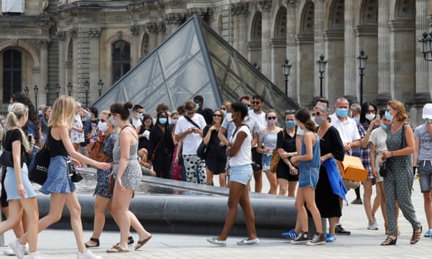 Visitors wearing protective face masks queue to enter the Louvre Pyramid in Paris, as France reinforces mask-wearing as part of efforts to curb a resurgence of the coronavirus.