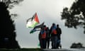 Pilgrims wearing fluorescent vests and carrying Palestinian flags