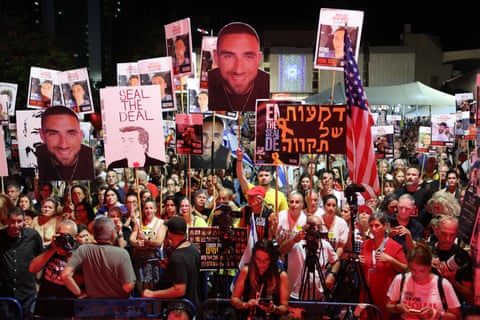 People raise placards and pictures of Israeli detainees during a rally organised by families of hostages in Hostage Square in Tel Aviv