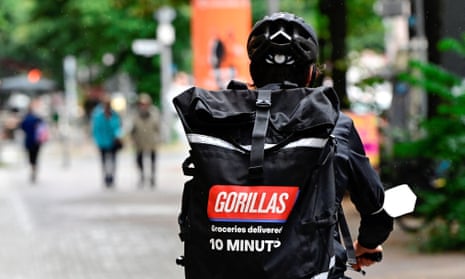 A courier for the fast-track grocery delivery company Gorillas cycles through Berlin to deliver purchases.