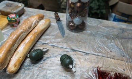 Fake grenades being used to decorate a Christmas tree sit alongside bread and other food before a new year’s meal.