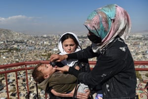 A health worker administers polio vaccine drops to a child during a vaccination campaign in the old quarter of Kabul, Afghanistan