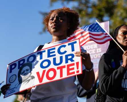 A protester holding a placard saying 'Protect our vote!' (Photographer: Eric Lee/Bloomberg via Getty Images)