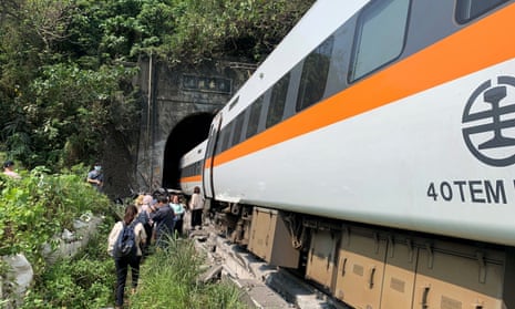 People walk next to a train which derailed in a tunnel north of Hualien, Taiwan April 2, 2021, in this handout image provided by Taiwan’s National Fire Agency. Taiwan’s National Fire Agency/Handout via REUTERS ATTENTION EDITORS - THIS IMAGE WAS PROVIDED BY A THIRD PARTY. NO RESALES. NO ARCHIVES.
