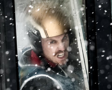 Slovenia’s Vid Vrhovnik considers the conditions as he rides the lift to the top of the ski jump.