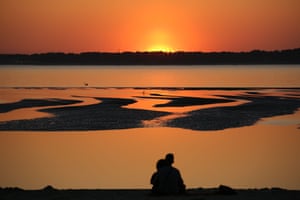 Les gens regardent le coucher de soleil sur le Cap Ferret, depuis une plage du bassin d'Arcachon