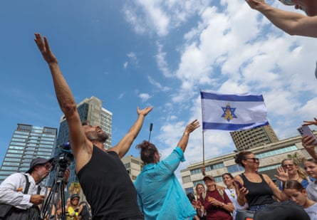Two people with hands in the air against blue sky celebrating