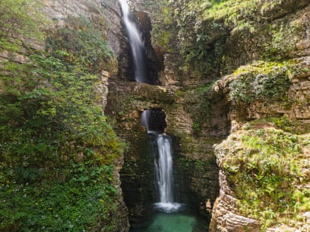 A waterfall cascades over moss-covered rocks