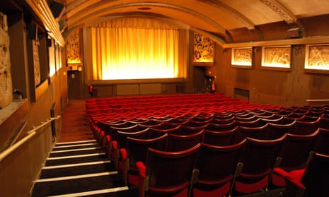 Interior of a cinema with rows of red seats