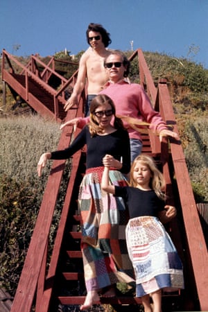 Didion and her family walk down a set of red wood steps near their Malibu beach home in a photo shot for Vogue in 1972. Didion and her daughter Quintana Roo Dunne wear matching patchwork skirts and black tops, her husband, John Gregory Dunne, and his nephew Anthony, follow behind.