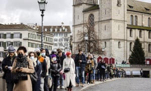 Swiss voters queue from Muenster Bridge to the Zurich City Hall to vote at a polling station.