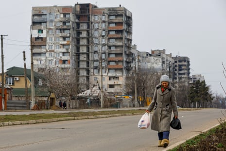 A local resident walks near multi-storey apartment blocks in Mariupol, Russian-controlled Ukraine.