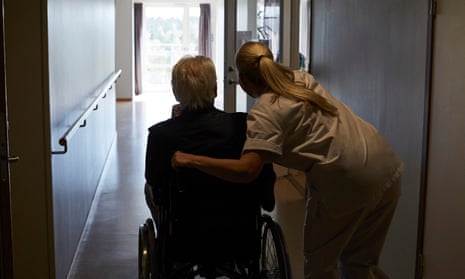 Rear view of female nurse with senior man sitting in wheelchair