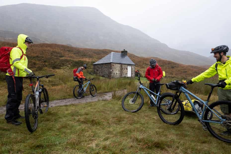 A radical  of upland  bikers depart Lairig Leacach Bothy wherever  they camped the night.