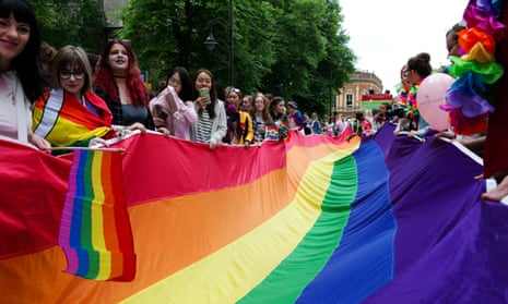 People hold a huge rainbow flag during the York Pride parade on 9 June in York, England. 