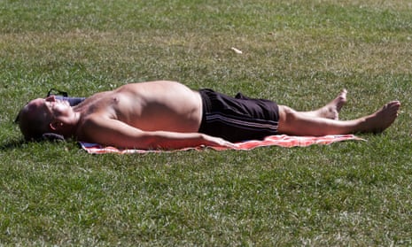 A man sunbathing in Green Park. 