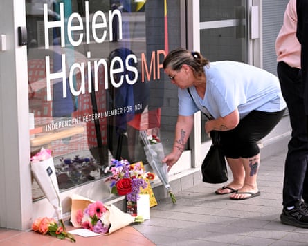 A woman places flowers outside the office of federal independent MP Helen Haines in the Victorian regional city of Wangaratta.