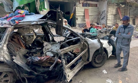 Onlookers check the car in which three sons of Hamas leader Ismail Haniyeh were killed in an Israeli airstrike in al-Shati camp