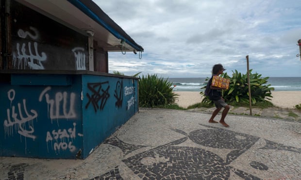 A street vendor walks past a closed beachside kiosk named Tropicalia, where Moïse Kabagambe was beaten to death.