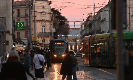 People boarding on and off a tram in Montpellier, France in the late evening. 