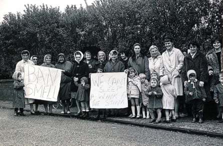 A black and white image of a group of women and children with banners reading: We can’t sleep a wink for the stink and Ban smell.