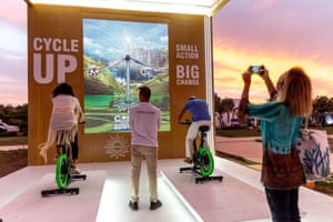 Visitors using bicycles to generate electricity in the green zone of the summit.