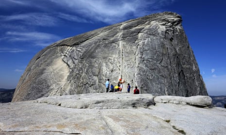Hikers gather as climbers use the assistance of cables to scale Half Dome in Yosemite national park.