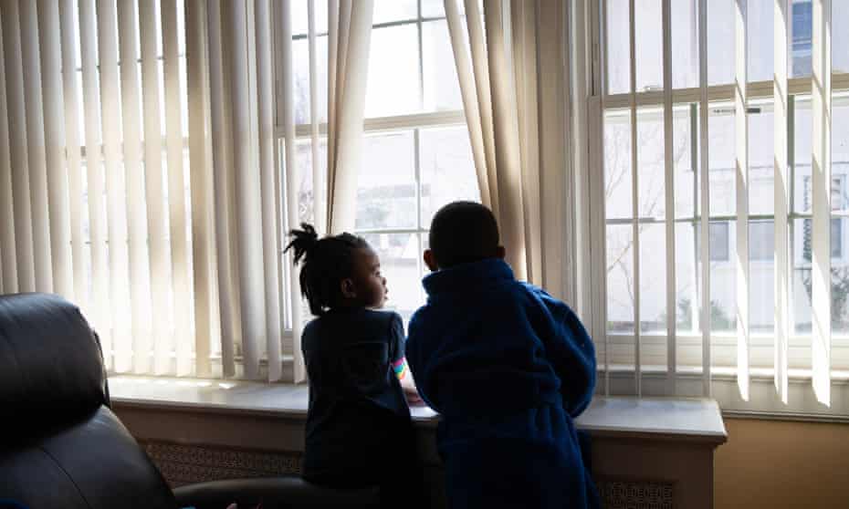 Marley Major, 4, and her brother Max, 5, look out a window of their home in Mount Vernon, New York. 