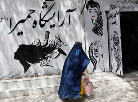 An Afghan woman walks past a beauty salon in the capital.